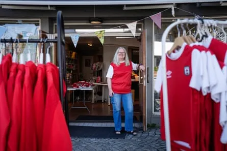 Olinda Haaland outside her shop with lots of red football shirts